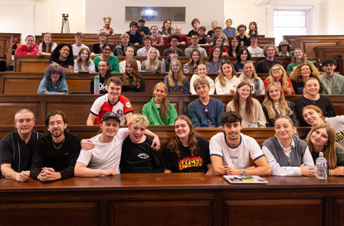 Jamie Webster and Alfie Skelly pictured sitting with students in the John Lennon Lecture Theatre